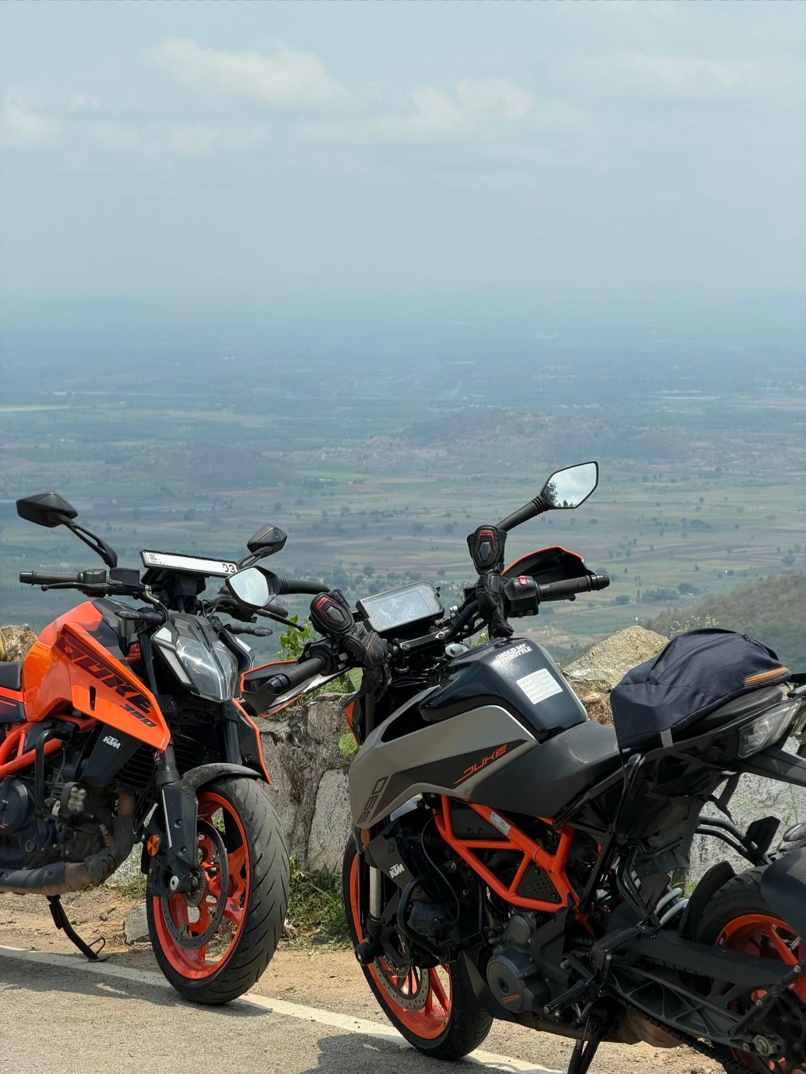 Two motorcycles parked at a mountain overlook