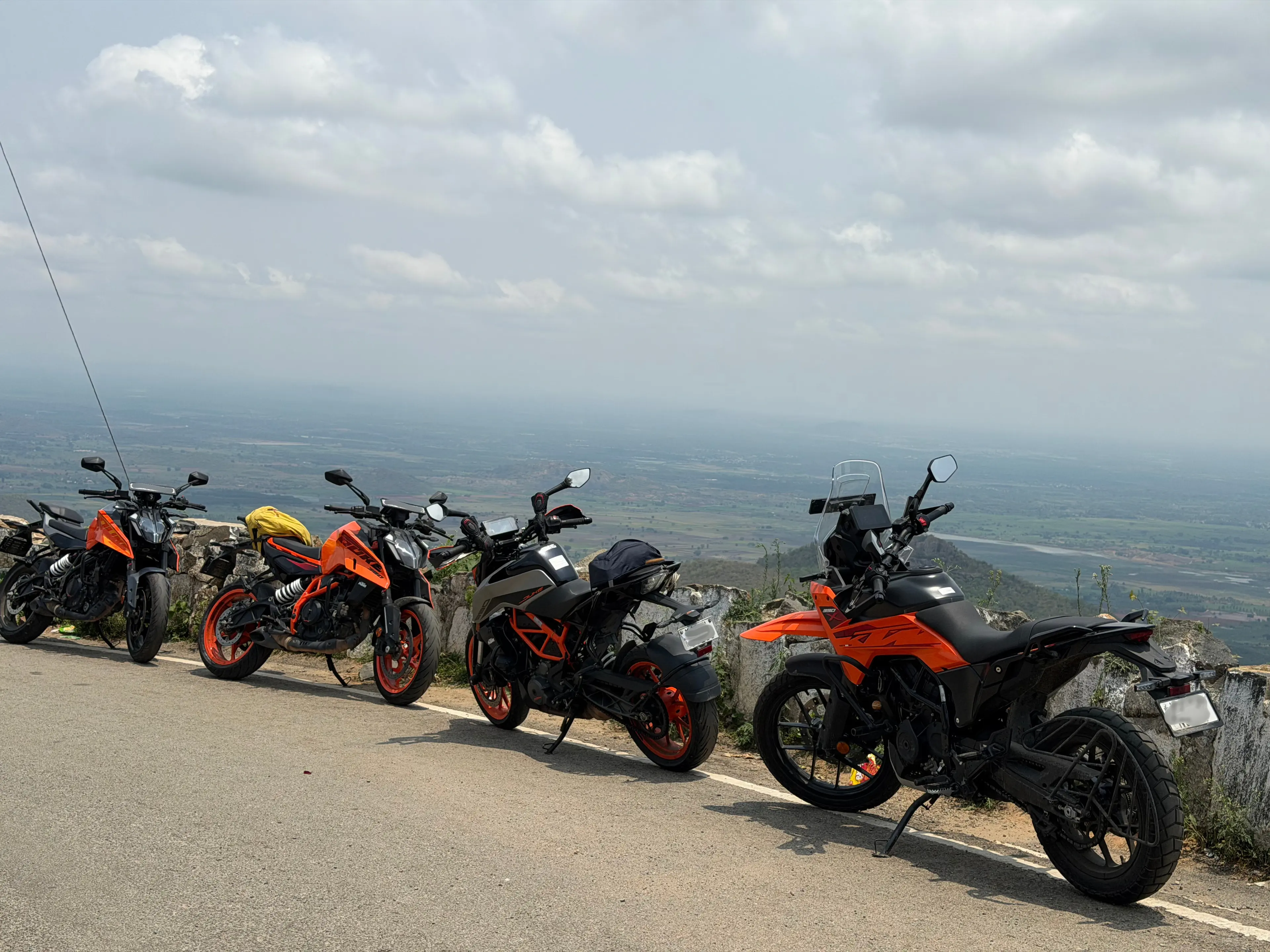 Four motorcycles parked at a mountain overlook